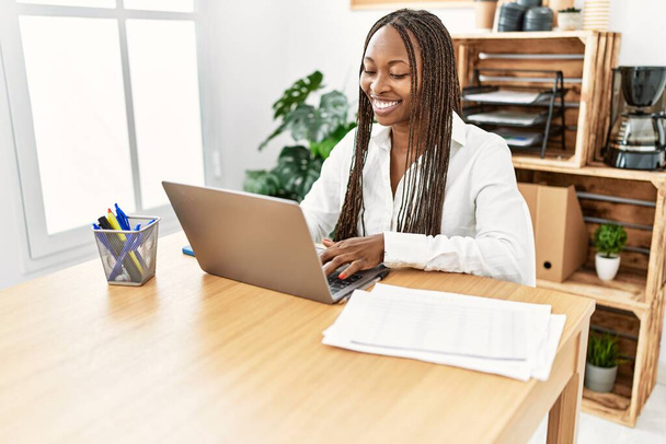 Молода афроамериканська комерсантка посміхається, що працює в офісі.. - Фото, зображення