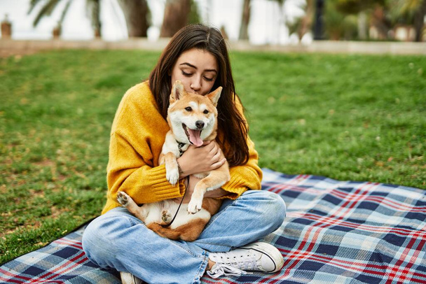 Krásná mladá žena líbání a objímání shiba inu pes v parku - Fotografie, Obrázek