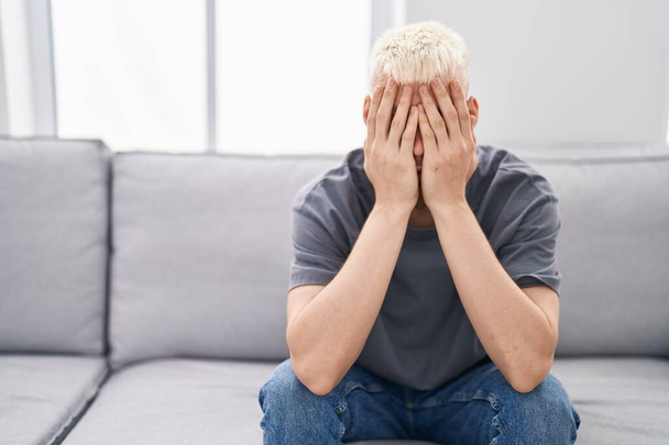 Young caucasian man stressed sitting on sofa at home - Photo, Image