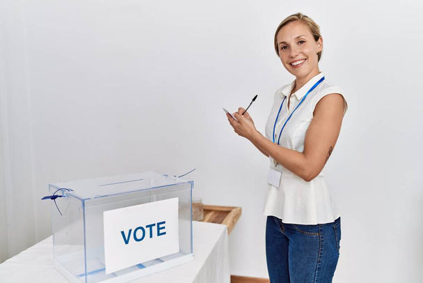 Молода біла жінка посміхається впевнено голосувати у виборчому коледжі
 - Фото, зображення