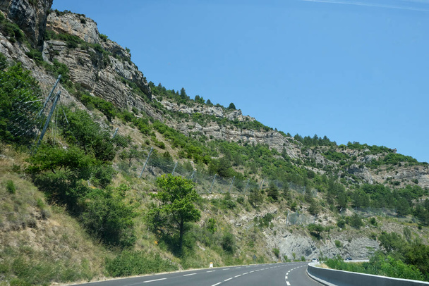 Vuori turva-aita suojata tien ja autojen putoamisen kiviä. Raskaat metalliverkko käytetään saalis putoaa kiviä kallioita suojellakseen autoja ajo moottoritiellä - Valokuva, kuva
