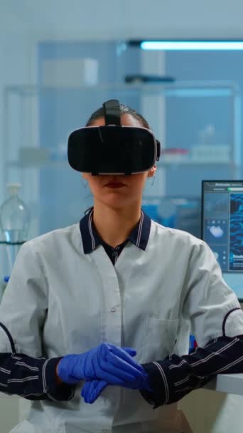 Vidéo verticale : Médecin de laboratoire expérimentant la réalité virtuelle en utilisant des lunettes vr dans le laboratoire de recherche médicale. Thérapeute utilisant des lunettes de dispositif d'innovation médicale, avenir, médecine, médecin - Séquence, vidéo