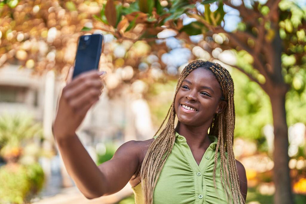 Afrikkalainen amerikkalainen nainen hymyilee luottavainen Varauksen selfie älypuhelimen puistossa - Valokuva, kuva