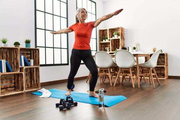 Middle age grey-haired woman smiling confident training yoga at home - Photo, Image