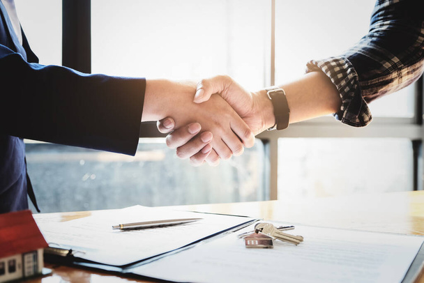 Focus on the congratulatory handshake. The real estate agent agrees to buy the home and hand the keys to the customer at the agents office. conceptual agreement - 写真・画像