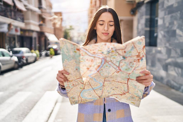 Junge schöne hispanische Frau schaut Stadtplan auf Straße - Foto, Bild