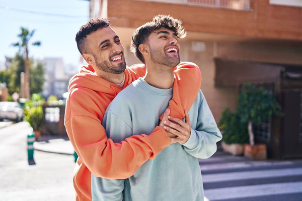 Two man couple hugging each other standing at street - Photo, Image
