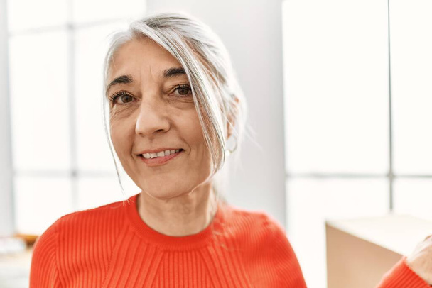 Middle age grey-haired woman smiling confident standing at new home - Photo, Image