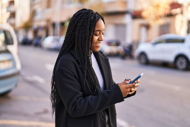 Africano americano mulher sorrindo confiante usando smartphone na rua - Foto, Imagem