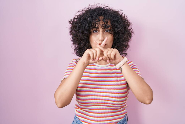 Jovem mulher do Oriente Médio em pé sobre rosa fundo rejeição expressão cruzando os dedos fazendo sinal negativo  - Foto, Imagem