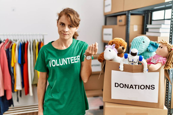 Mulher branca bonita vestindo t-shirt voluntária em doações stand fazendo gesto italiano com mão e dedos expressão confiante  - Foto, Imagem