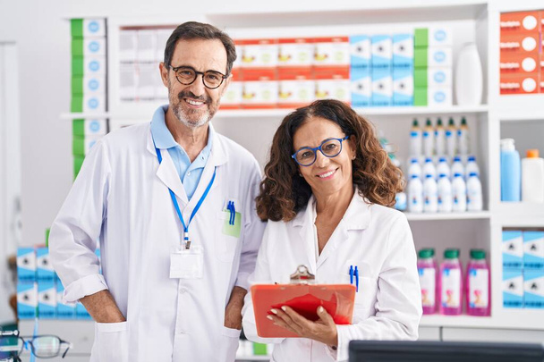 Férfi és női gyógyszerészek a gyógyszertárban dolgozó dokumentumokról írnak - Fotó, kép