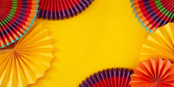 Colorful paper ornaments on yellow background - Fotoğraf, Görsel