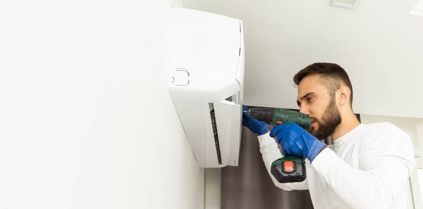 Mężczyzna technika naprawy klimatyzatora w pomieszczeniu - Zdjęcie, obraz