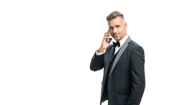 cheerful man in tuxedo speak on phone isolated on white background. - Foto, imagen