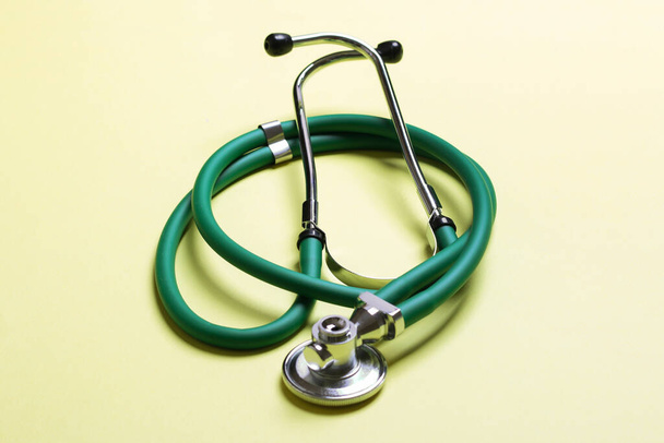 Horní pohled na zelené lékařské stetoskop na barevném pozadí s kopírovacím prostorem. Koncept lékařského vybavení. - Fotografie, Obrázek