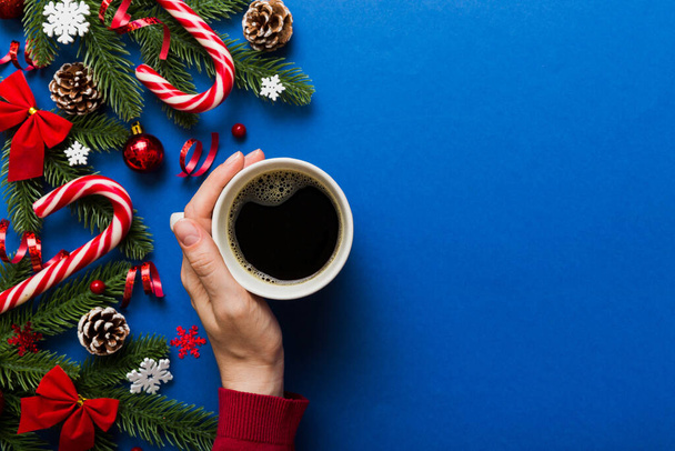 Frau mit Tasse Kaffee. Frauenhände halten einen Becher mit heißem Kaffee in der Hand. Winter- und Weihnachtszeitkonzept. - Foto, Bild
