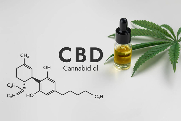 CBD oil in a clear, glass bottle with a dropper lid, isolated on a white background and biochemistry formula hexagon illustration, to represent the legalized marijuana extracts concept. - Foto, Imagen