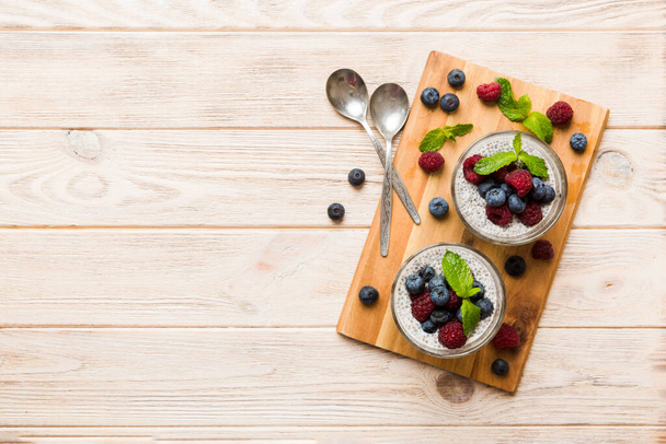 Healthy breakfast or morning with chia seeds vanilla pudding raspberry and blueberry berries on table background, vegetarian food, diet and health concept. Chia pudding with raspberry and blueberry. - Foto, Bild