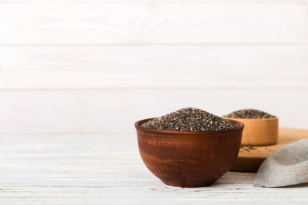 Chia seeds in bowl on colored background. Healthy Salvia hispanica in small bowl. Healthy superfood. - Photo, Image