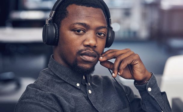 Ask me anything about architecture. Cropped portrait of a handsome young male architect wearing headphones while sitting in a modern office - Fotografie, Obrázek