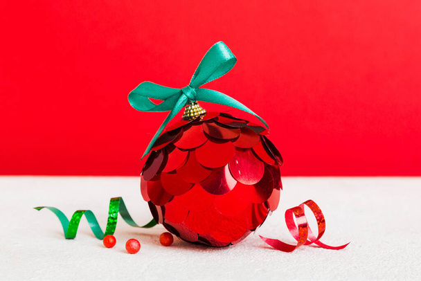 Christmas ball on colored background. decoration bauble with ribbon bow with copy space. - Photo, Image