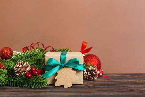 Πρωτοχρονιά Χριστούγεννα διάθεση, κουτί δώρου, κλαδιά ενός χριστουγεννιάτικου δέντρου, διακοσμήσεις Πρωτοχρονιάς σε έγχρωμο φόντο. - Φωτογραφία, εικόνα