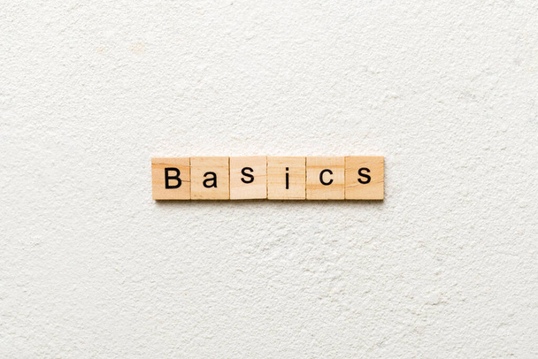 Slovo BASICS napsané na dřevěném špalku. BASICS text na stole, koncept. - Fotografie, Obrázek