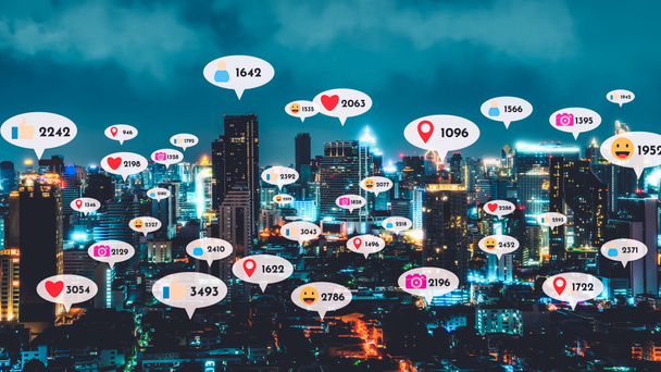 ソーシャルメディアのアイコンは、ソーシャルネットワークアプリケーションプラットフォームを介して人々の相互接続を示すダウンタウン上を飛ぶ。オンラインコミュニティとソーシャルメディアマーケティング戦略の概念 . - 写真・画像