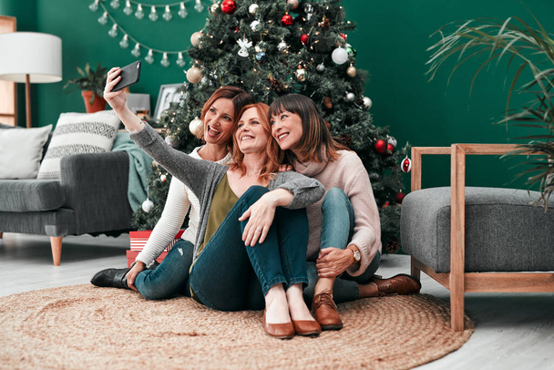 Even mooi. drie aantrekkelijke vrouwen het nemen van Kerstmis selfies samen thuis - Foto, afbeelding
