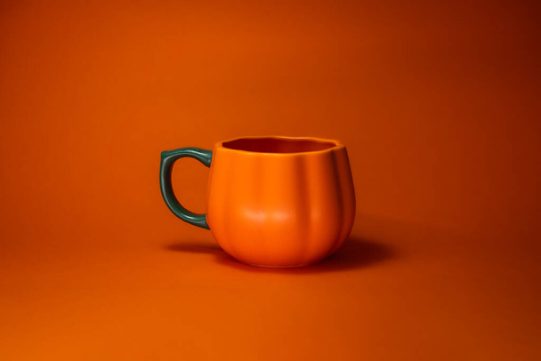 tasse de café orange isolé sur fond rouge - Photo, image
