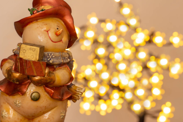 Ambiente navideño con muñeco de nieve, dos velas y bokeh - Foto, Imagen