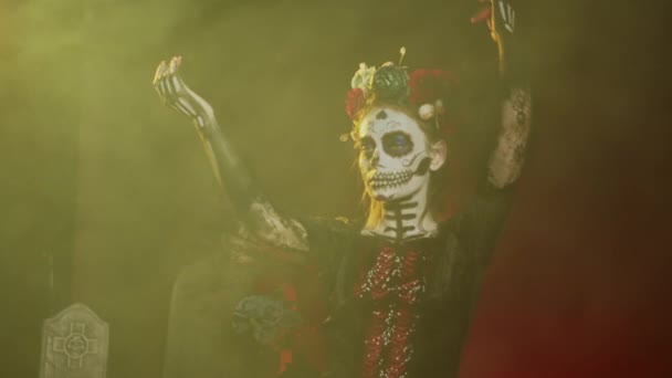 Femme glamour avec crâne de sucre maquillage et bandeau de fleurs, vêtue en costume de déesse de la mort comme Santa Muerte. Dios de los muertos art pour célébrer la tradition mexicaine en studio. Coup de main. - Séquence, vidéo