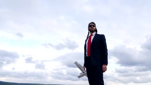 Unternehmer mit Pilotenhut und Brille mit Flugzeug am Himmel, wendiges Geschäft. - Filmmaterial, Video
