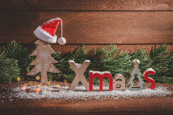 Merry Christmas. Wooden Christmas decorations and fir branches on a wooden background - Фото, зображення