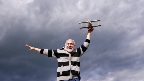 Šťastný starý muž hrát letadlo létání na obloze, předstírat. - Záběry, video
