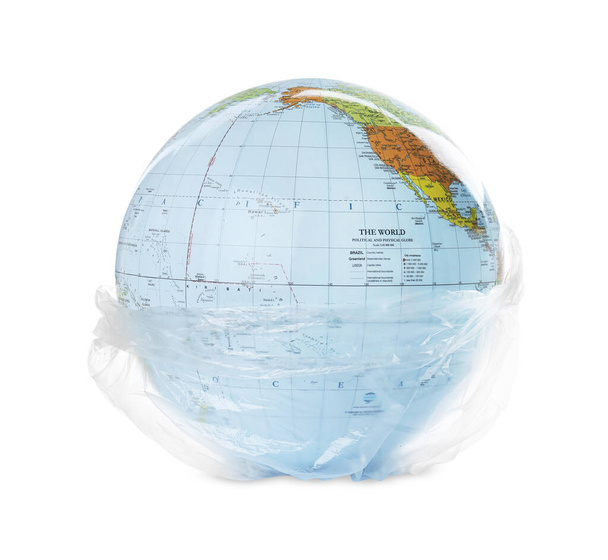 Globe in plastic bag isolated on white. Environmental conservation - Photo, image