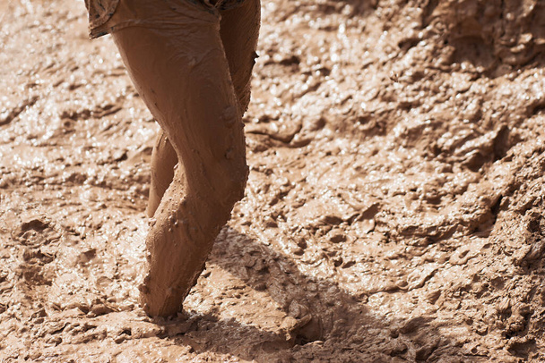 Mud race runner participant wades through, muddy feet - Fotoğraf, Görsel
