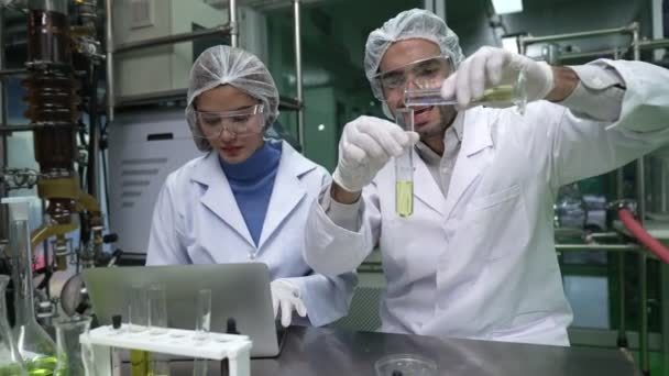 Kimyasal ve biyomedikal deneyler için tedavi laboratuvarında çalışan profesyonel üniformalı iki bilim adamı. - Video, Çekim