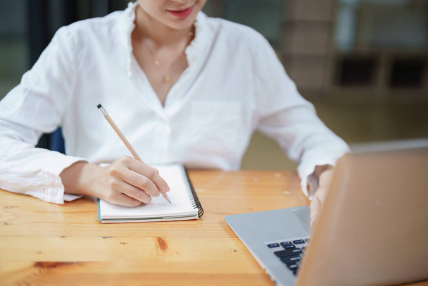 γυναίκα που χρησιμοποιεί ένα σημειωματάριο και τον υπολογιστή κατά τη διάρκεια μιας τηλεδιάσκεψης, e μάθηση έννοιες - Φωτογραφία, εικόνα