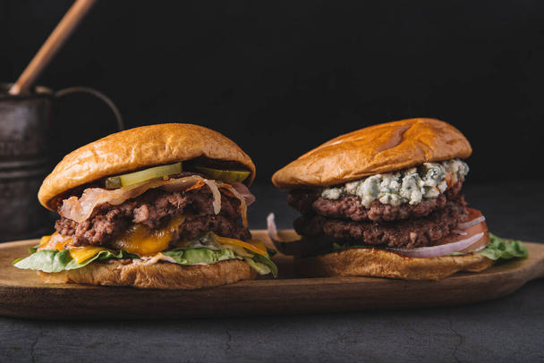 detail dvojitých hamburgerů na dřevěné desce - Fotografie, Obrázek