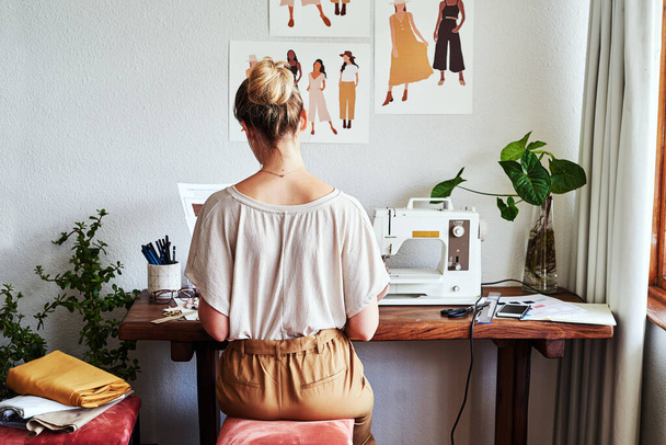 When Im busy creating, all my focus goes into it. a young fashion designer using a sewing machine in her workshop - Fotografie, Obrázek