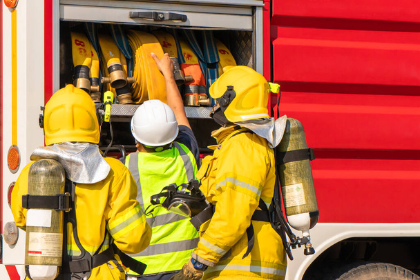 Palomiehen koulutus, Palomiehet valmistavat laitteita paloautoista paloletkuharjoituksiin tehtaalla - Valokuva, kuva