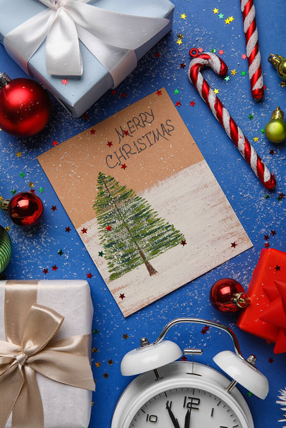 Kerstcompositie met wenskaart, decoraties en geschenken op kleur achtergrond, close-up - Foto, afbeelding