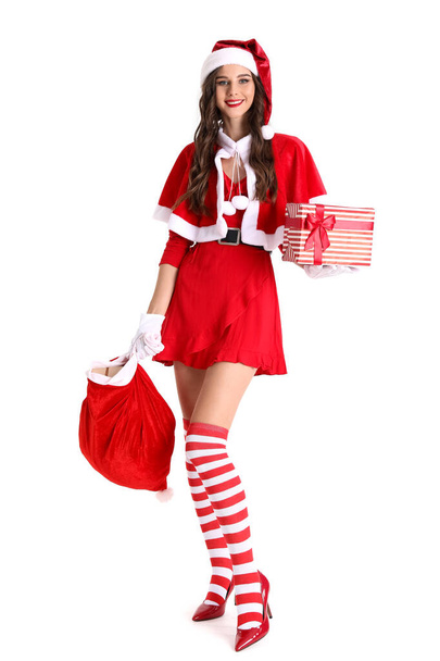 Mooie vrouw in Santa kostuum met tas van geschenken op witte achtergrond - Foto, afbeelding