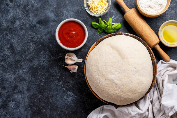 Raw dough with ingredients for cooking pizza. Sourdough pizza, baking at home. - Фото, зображення