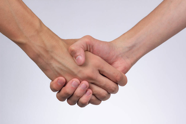 kräftiger männlicher Händedruck mit bloßen Händen auf weißem Hintergrund - Foto, Bild