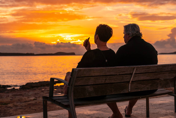 An elderly couple on the promenade at sunset in San Antonio Abad, Ibiza Island - Fotoğraf, Görsel