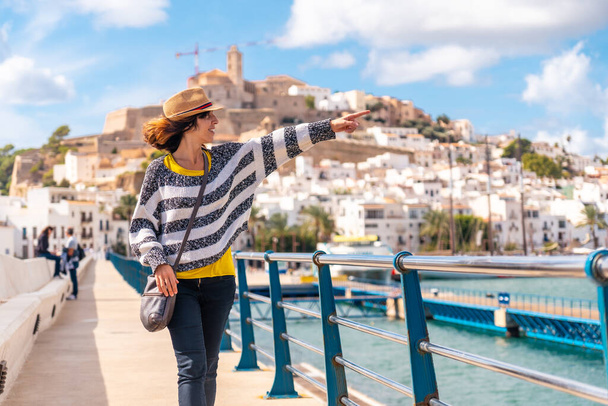 Young woman with hat visiting coastal Ibiza town on vacation from Al Faro, Balearic Islands - Fotografie, Obrázek