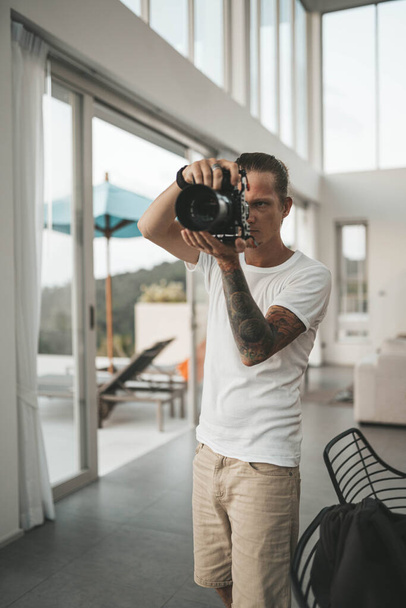 Man photographer is shooting in the villa. High quality photo - Foto, afbeelding
